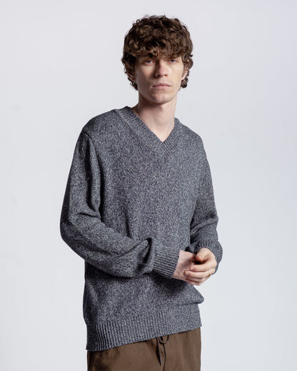 Man wearing a gray sweater against a plain background